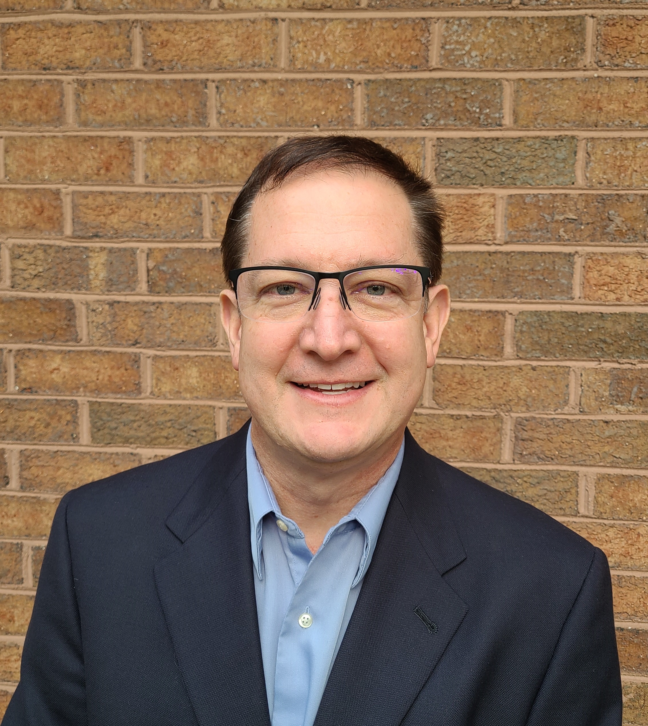 a photo of kevin osborn in front of a brick wall