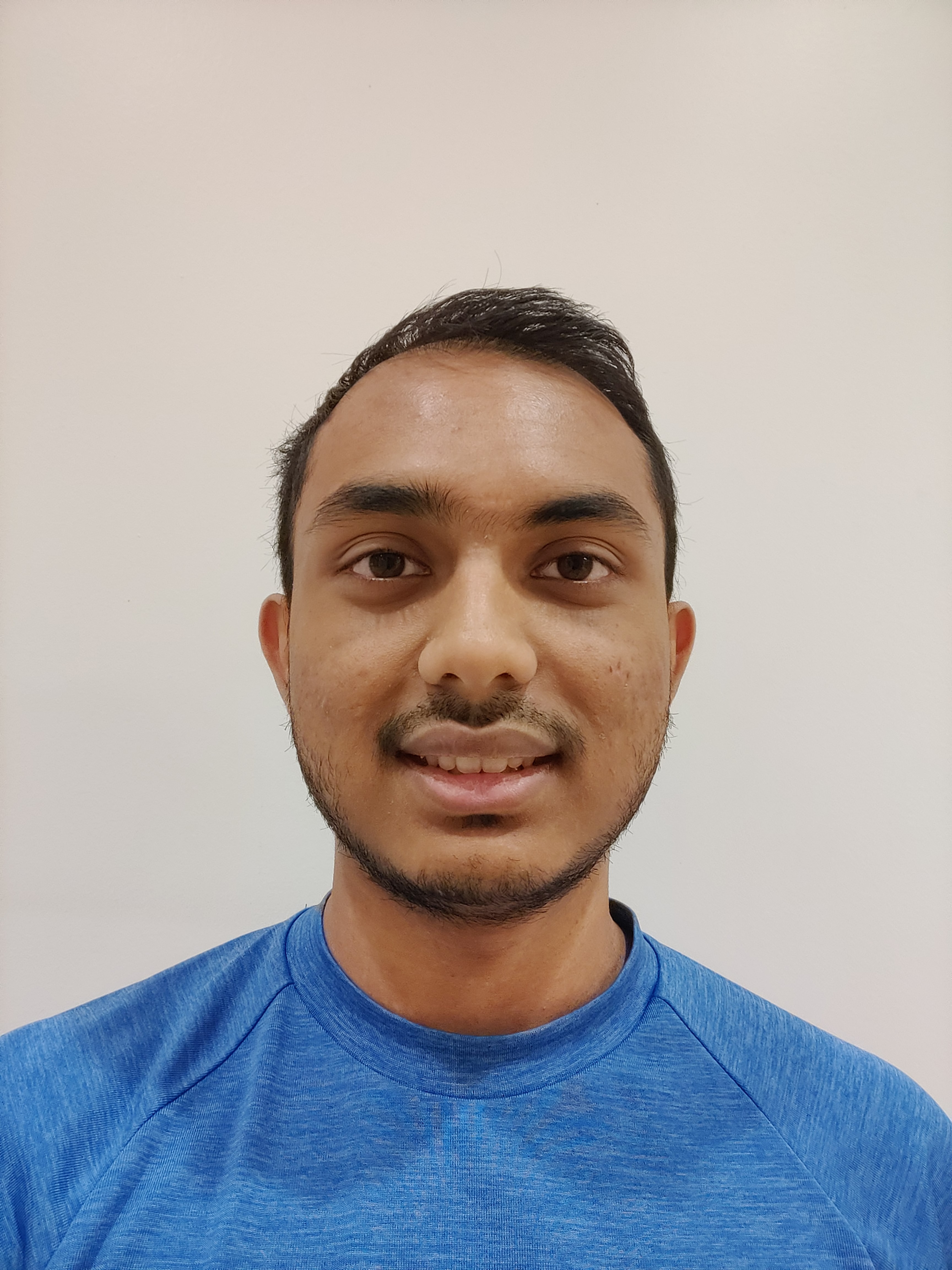 A photo of Mohammad Alam, wearing a blue shirt and smiling.