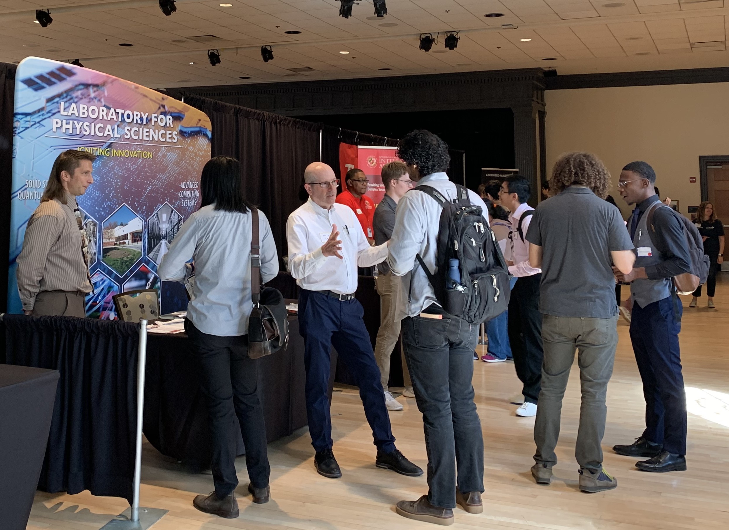 Attendees and exhibitors talking around the LPS booth at the 2024 Quantum Leap Career Nexus