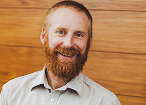 a photo of a smiling man with a beard